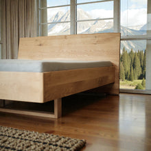 Lade das Bild in den Galerie-Viewer, Eichenholzbett mit Alpenblick – massives Holzbett in Tiroler Bergchalet, natürliche Holzmaserung und authentisches Alpenambiente